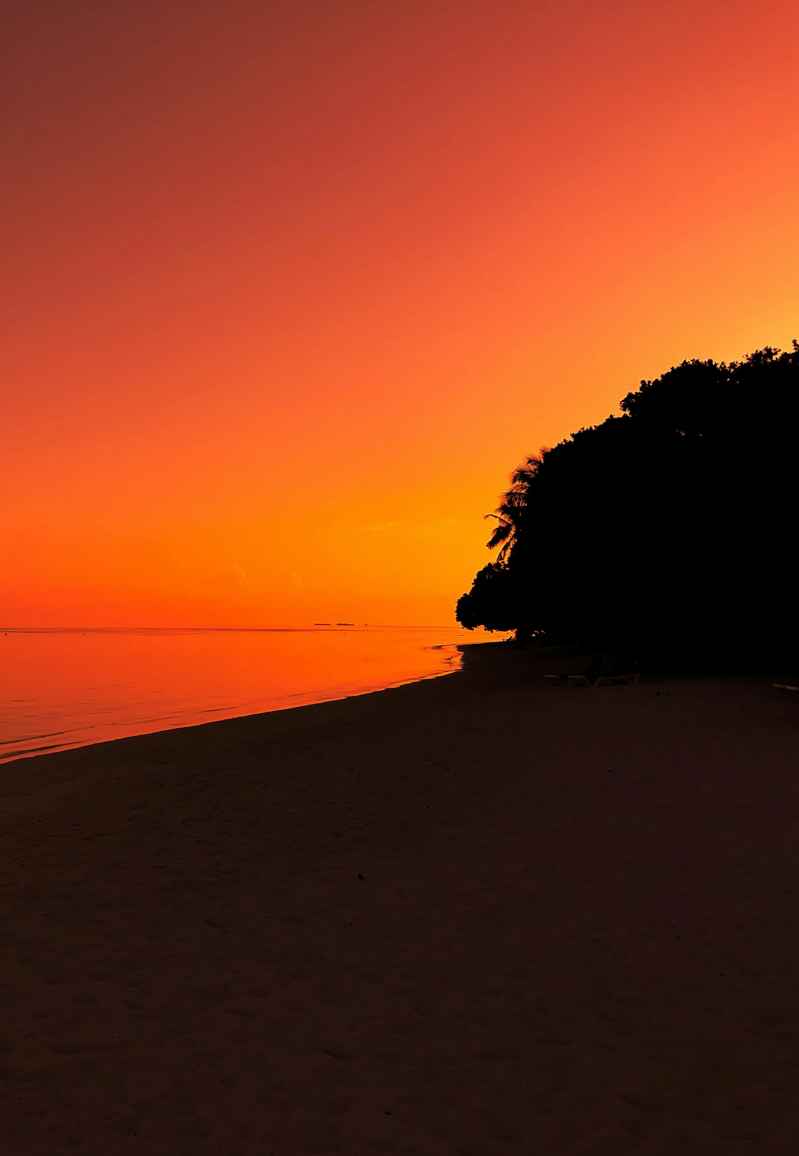 Tangalle beach Sri Lanka at sunset, dramatic orange sky, calm ocean, remote tropical coastline